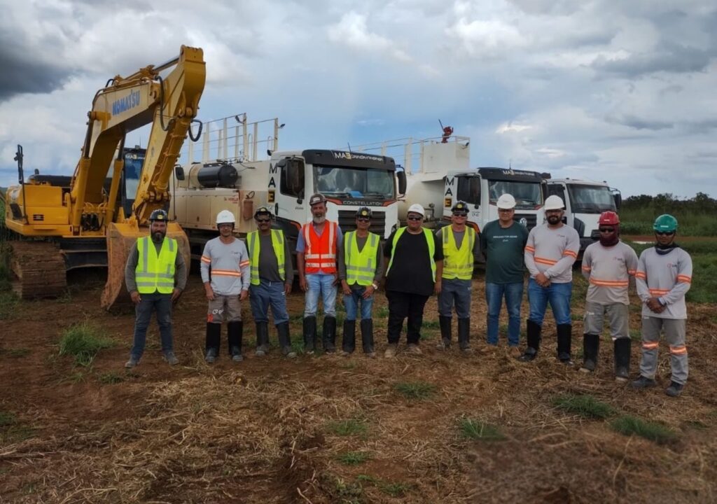 Equipe da Gali Energia posando em frente a escavadeira em canteiro de obras, celebrando marco de início dos processos de terraplanagem da Subestação Paracatu 9.