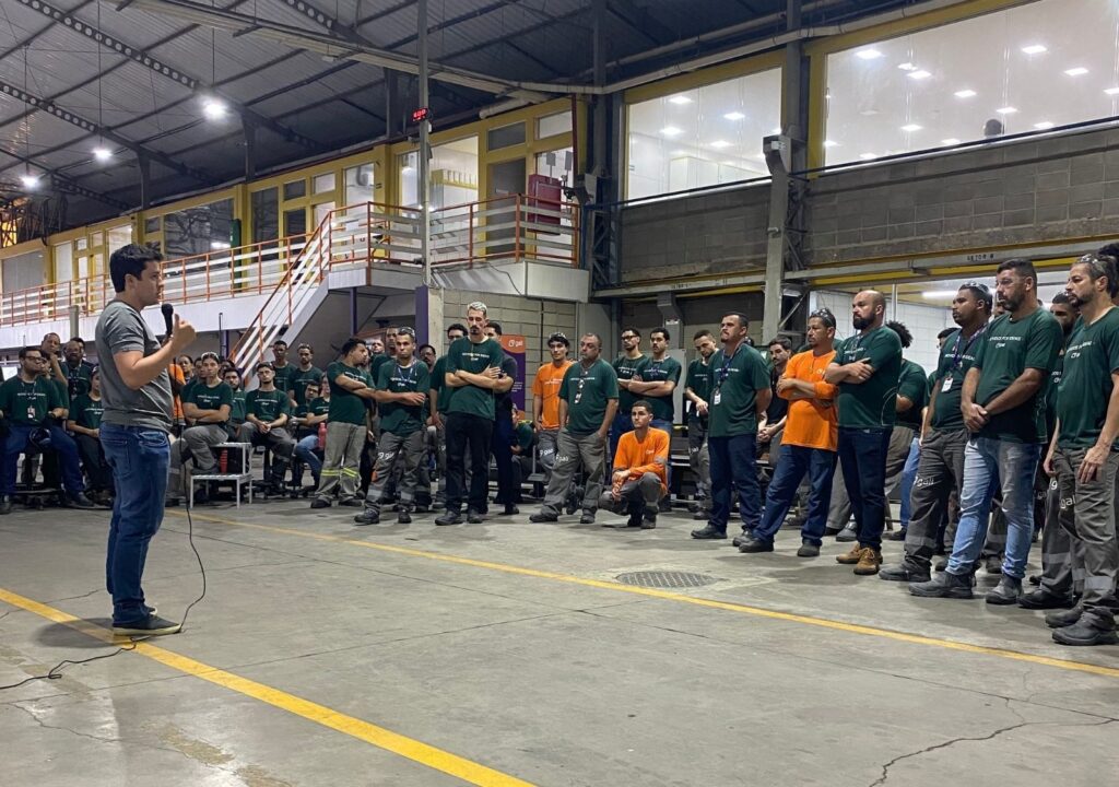 Equipe diversa da Gali Energia em ambiente industrial, reunida para ouvir o diretor de operações Gabriel Daré durante a primeira edição de 2026 do Projeto Galileu.